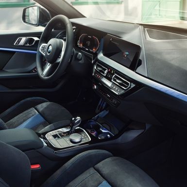 Sportiškas 1 serijos BMW interjeras BMW 1 serijos vairuotojo erdvė su M Sport sėdynėmis, M odiniu vairu ir apšviestais interjero apdailos elementais