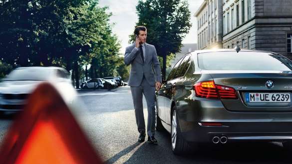 BMW pagalbos kelyje paslauga Roadside Assistance BMW pagalbos kelyje paslauga Roadside Assistance vyras su telefonu rankose prie BMW automobilio