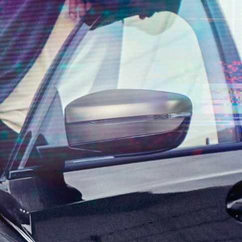 BMW 3 serijos sedanas, veidrodėlių gaubtai. Atvirų vairuotojo durelių su Cerium pilko metaliko spalvos veidrodėlių gaubtais priartintas vaizdas iš šono.