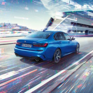 BMW 3 serijos sedanas, vaizdas iš galinio šono Miesto fone dieną stovinčio BMW 3 serijos sedano trijų ketvirčių vaizdas iš galo