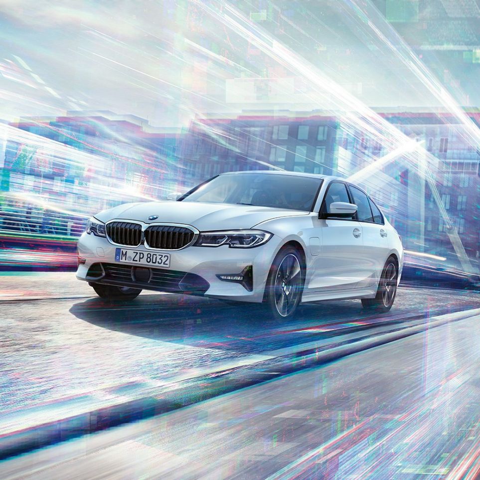 Keliu važiuojantis BMW 3 serijos sedanas BMW 3 serijos sedanas 330e važiuojantis miesto fone
