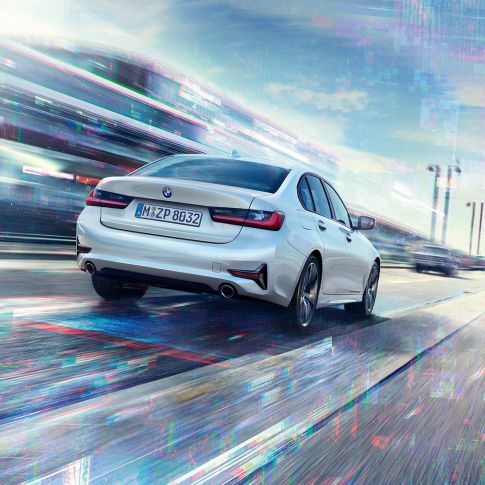 BMW 3 serijos sedano 330e vaizdas iš galo Keliu važiuojančio BMW 3 serijos sedano 330e trijų ketvirčių vaizdas iš galo