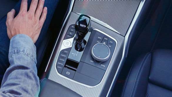 BMW 3 serijos sedanas (G20), <i>Steptronic Sport</i> transmisija Priartintas BMW 3 serijos sedano (G20) centrinės konsolės vaizdas iš paukščio skrydžio su pavarų perjungimo svirtimi ir <i>Steptronic Sport</i> transmisija.