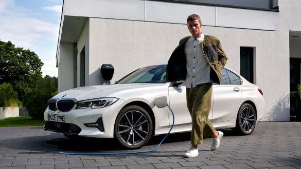 Įkraunamas hibridinis BMW 3 serijos sedanas (G20) 2021, trijų ketvirčių vaizdas iš priekio įkrovimo stotelėje Įkraunamas hibridinis BMW 3 serijos sedanas (G20) 2021, trijų ketvirčių vaizdas iš priekio įkrovimo stotelėje su modeliu