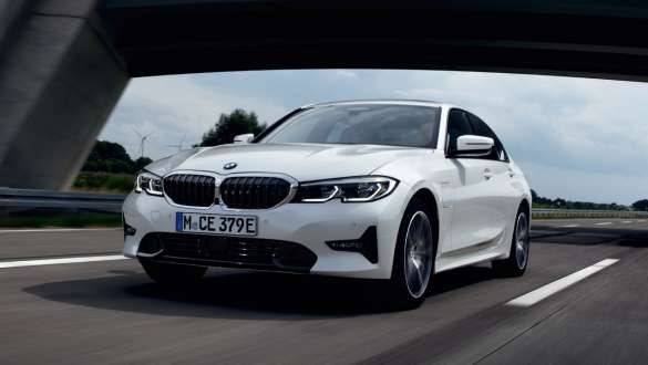 Įkraunamas hibridinis BMW 3 serijos sedanas (G20) 2021, važiuojančio automobilio trijų ketvirčių vaizdas iš priekio Įkraunamas hibridinis BMW 3 serijos sedanas (G20) 2021, gatve važiuojančio automobilio trijų ketvirčių vaizdas iš priekio