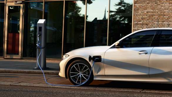 Įkraunamas hibridinis BMW 3 serijos sedanas (G20) 2021, vaizdas iš šono Įkraunamas hibridinis BMW 3 serijos sedanas (G20) 2021, vaizdas iš šono įkrovimo stotelėje
