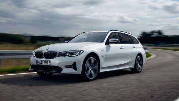 Įkraunamas hibridinis BMW 3 serijos Touring (G21) 2021, važiuojančio automobilio trijų ketvirčių vaizdas iš priekio Įkraunamas hibridinis BMW 3 serijos Touring (G21) 2021, gatve važiuojančio automobilio trijų ketvirčių vaizdas iš priekio
