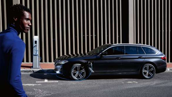 Įkraunamas hibridinis BMW 5 serijos Touring (G31) 2021 LCI, vaizdas iš šono įkrovimo stotelėje Įkraunamas hibridinis BMW 5 serijos Touring (G31) 2021 LCI, vaizdas iš šono įkrovimo stotelėje su modeliu