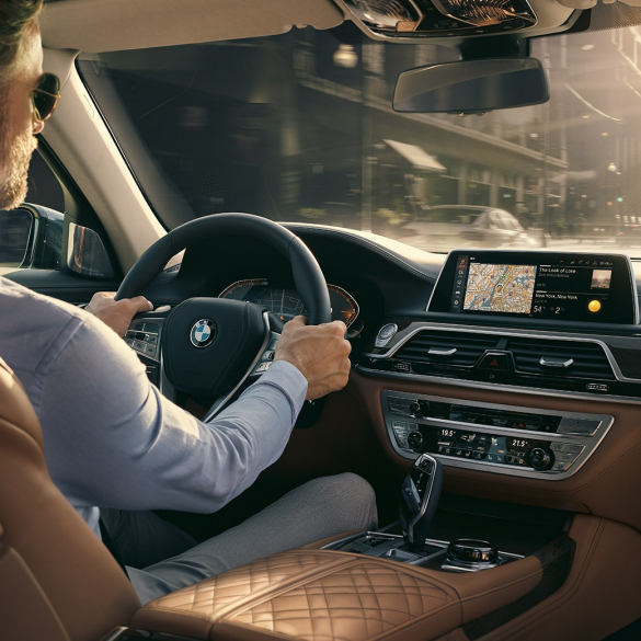 BMW 7 serijos sedano ryšio funkcijos BMW 7 serijos sedanas: vyras sėdi BMW ir naudojasi ryšio funkcijomis