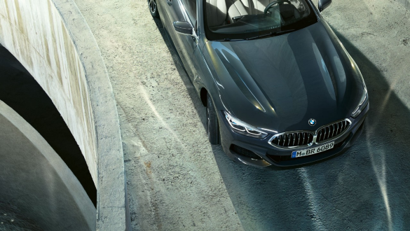 BMW M850i xDrive „Dravit Grey“ pilko metaliko spalvos,važiuojantis keliu, vaizdas iš priekio iš paukščio skrydžio, „Integral Active Steering“ integruoto aktyvaus vairavimo sistema. BMW M850i xDrive „Dravit Grey“ pilko metaliko spalvos,važiuojantis keliu, vaizdas iš priekio iš paukščio skrydžio, „Integral Active Steering“ integruoto aktyvaus vairavimo sistema.