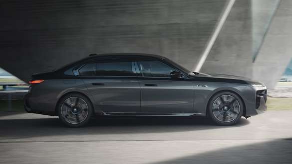 Elektra nuvažiuojamas atstumas BMW M760e xDrive sedanas G70 M Performance paketas Elektra nuvažiuojamas atstumas BMW M760e xDrive sedano G70 M Performance paketas BMW Individual dviejų atspalvių Black Sapphire juoda metalizuota dažų apdaila BMW Individual Dravite Grey pilka metalizuota dažų apdaila važiuojančio gatve automobilio vaizdas iš šono