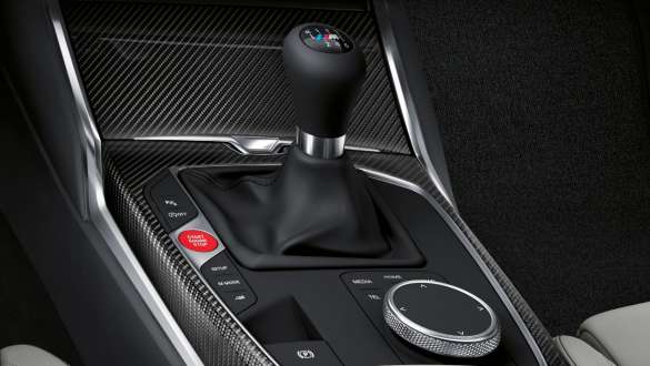 Mechaninė M transmisija ir galinių varomų ratų pavara BMW M4 kupė G82 2020 BMW M4 kupė G82 2020 mechaninė 6 pavarų M transmisija ir galinių varomų ratų pavara, centrinės konsolės ir pavarų svirties vaizdas iš arti