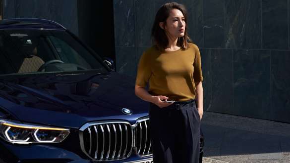 Moteris stovinti priešais BMW BMW pagalba kelyje moteris stovinti priešais BMW
