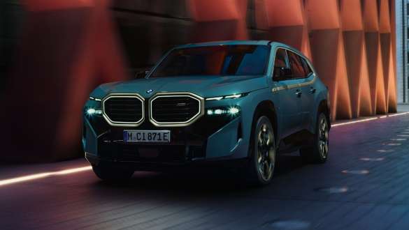 BMW XM G09 V8 įkraunamo hibrido vaizdas iš šono BMW XM G09 V8 įkraunamo hibrido vaizdas iš šono pastato fone