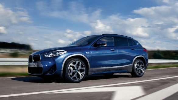 Įkraunamas hibridinis BMW X2 xDrive25e (F39), trijų ketvirčių vaizdas iš šono Įkraunamas hibridinis BMW X2 xDrive25e (F39), gatve važiuojančio automobilio trijų ketvirčių vaizdas iš šono