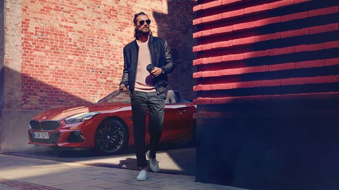 BMW Z4 Roadster siauroje gatvelėje Vyras, stovintis prie BMW Z4 Roadster siauroje gatvelėje
