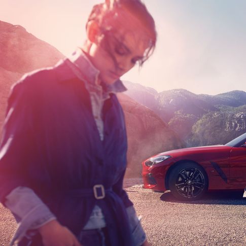BMW Z4 Roadster vaizdas iš priekio kalnų fone Vyras, moteris ir BMW Z4 Roadster kalnų fone