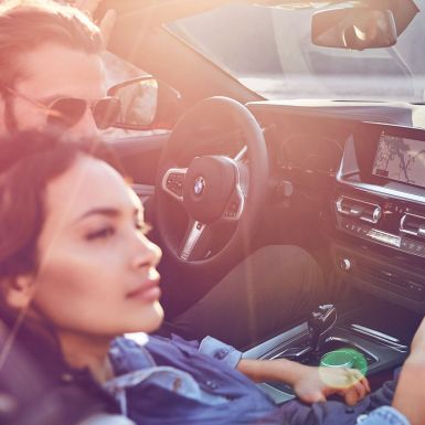 BMW Z4 Roadster su moterimi ir vyru Tamsiaplaukė moteris ir vyras sėdintys BMW Z4 Roadster