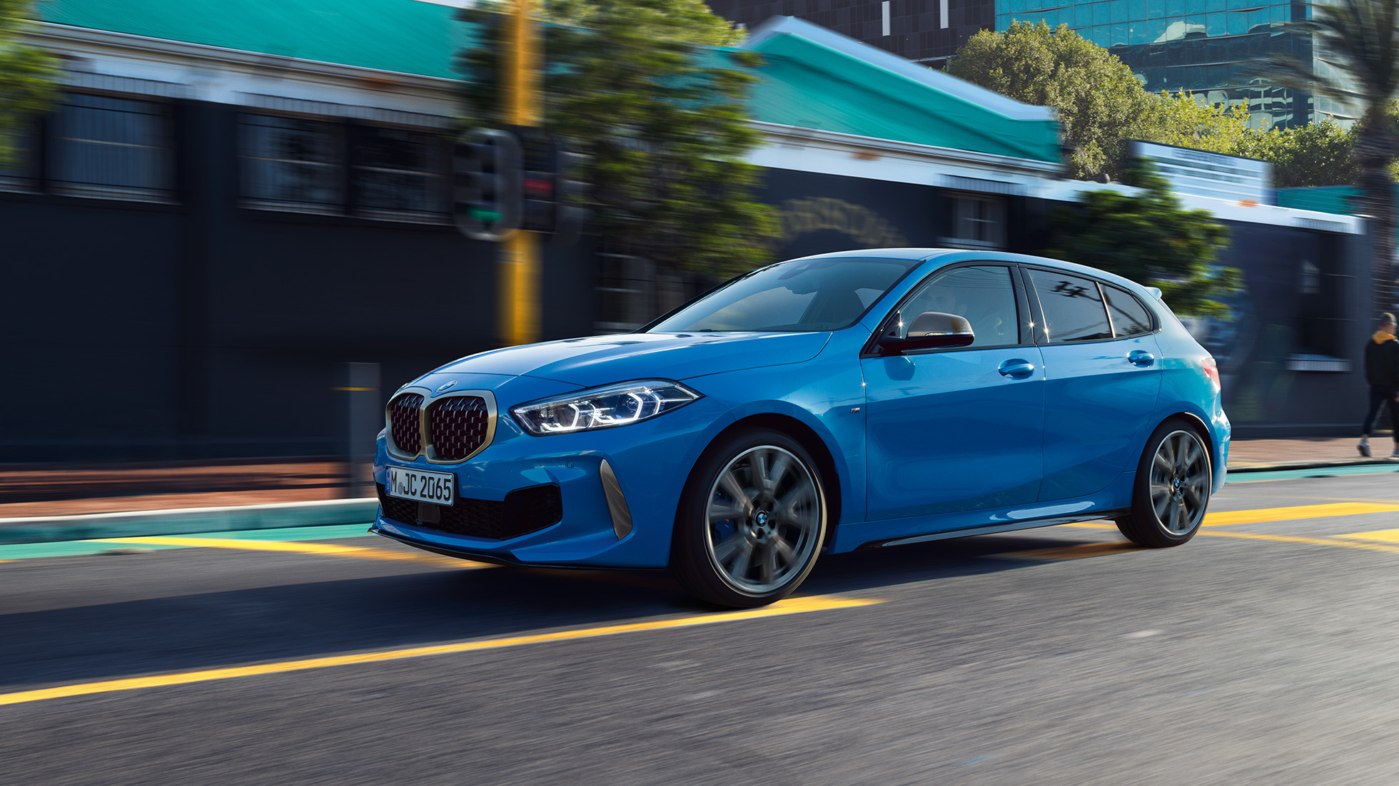 BMW 1 serijos modelis, trijų ketvirčių vaizdas iš šono Misano Blue mėlyno metaliko spalvos BMW 1 serijos modelis, trijų ketvirčių vaizdas iš priekio važiuojant