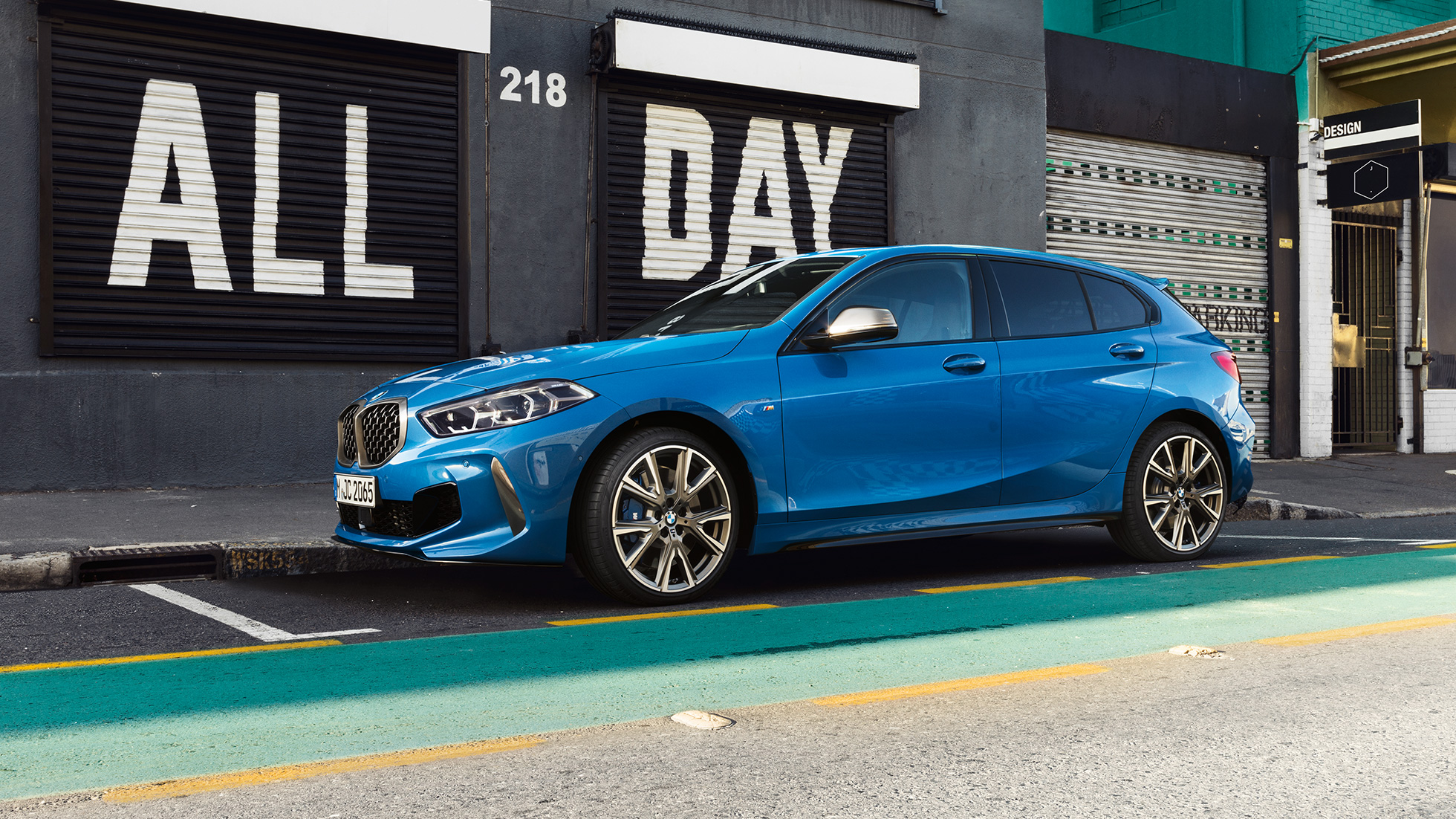1 serijos BMW parkavimas Misano Blue mėlyno metaliko spalvos 1 serijos BMW, vaizdas iš šono parkavimosi aikštelėje