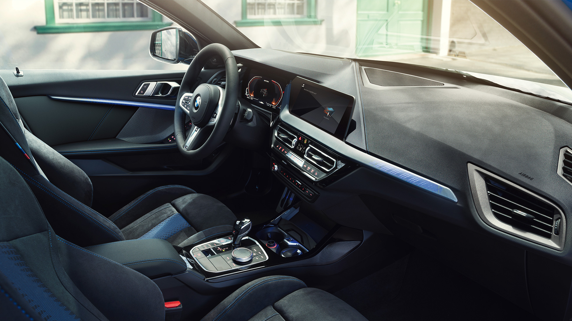 Sportiškas 1 serijos BMW interjeras BMW 1 serijos vairuotojo erdvė su M Sport sėdynėmis, M odiniu vairu ir apšviestais interjero apdailos elementais