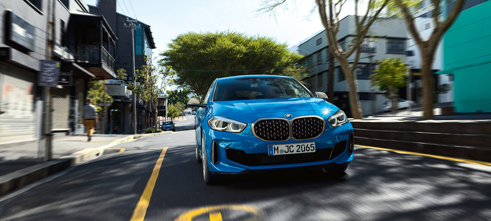 BMW 1 serija F40 mėlynos metalizuotos Misano Blue kėbulo spalvos, važiuojančio automobilio vaizdas iš priekio