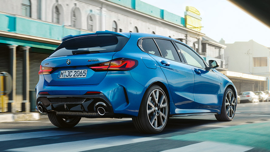 BMW 1 serijos F40, važiuojančio automobilio trijų ketvirčių vaizdas iš galo BMW 1 serijos F40 mėlynos metalizuotos Misano Blue spalvos, važiuojančio automobilio trijų ketvirčių vaizdas iš galo