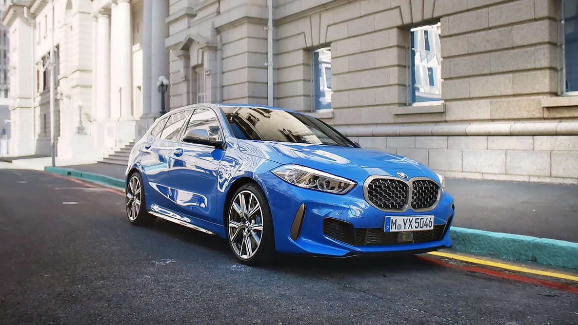 BMW 1 serijos F40 stovėjimo aikštelėje BMW 1 serijos F40 mėlynos metalizuotos Misano Blue spalvos, vaizdas iš šono stovėjimo aikštelėje