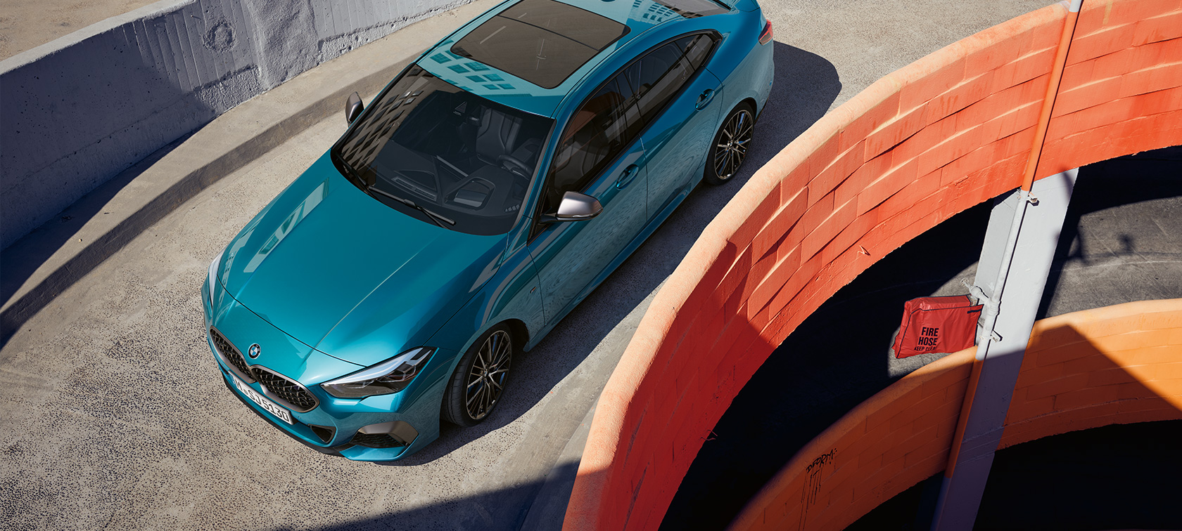 BMW 2 serijos Gran kupė (F44) trijų ketvirčių priekinis vaizdas iš viršaus BMW 2 serijos Gran kupė (F44) mėlynos metalizuotos <i>Snapper Rocks Blue</i> kėbulo spalvos, trijų ketvirčių priekinis vaizdas iš viršaus