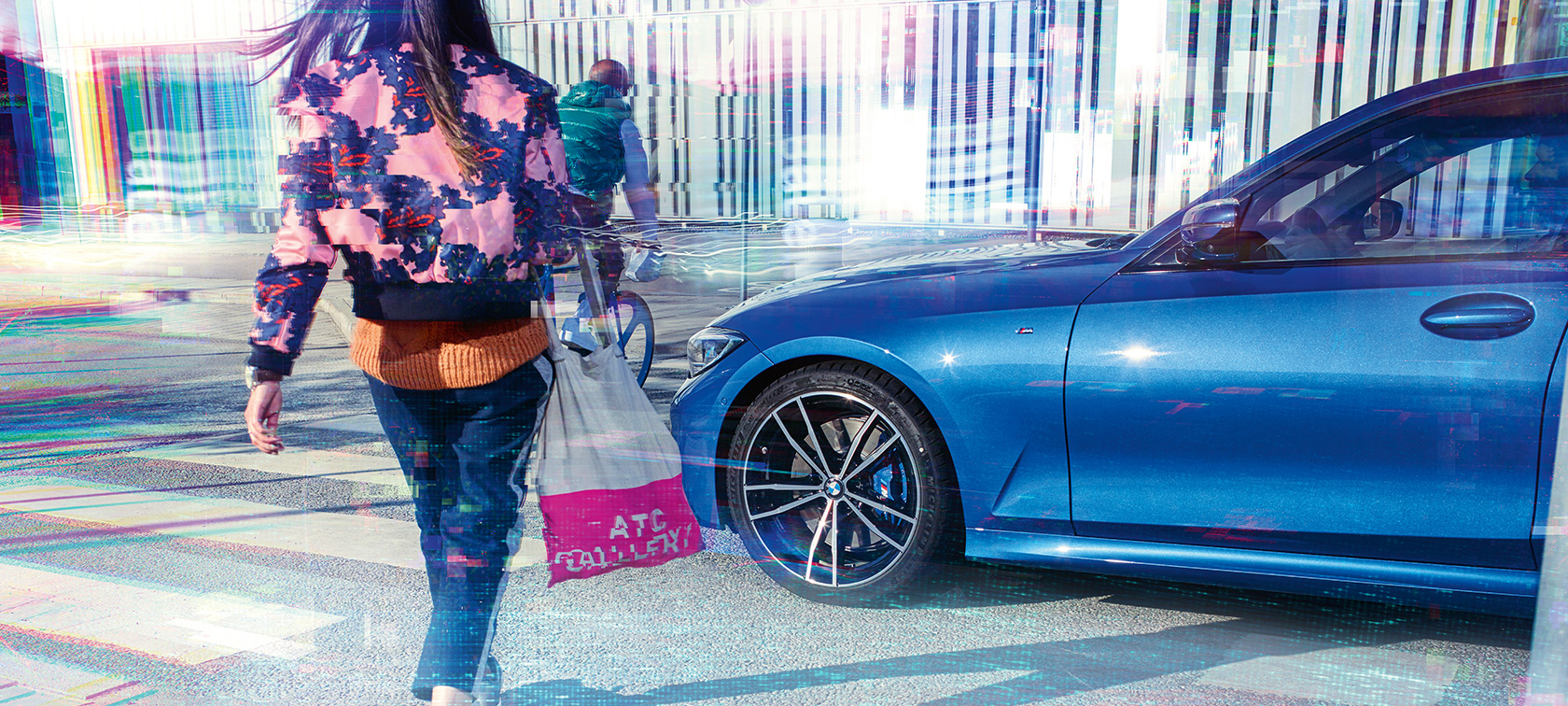 BMW 3 serijos sedanas, trijų ketvirčių vaizdas iš šono BMW 3 serijos sedano, stovinčio ant asfalto trijų ketvirčių vaizdas iš šono miesto fone su keleiviais