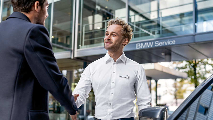 BMW aptarnavimo skyriaus darbuotojas pasitinka klientus BMW aptarnavimo skyriaus darbuotojas pasitinka klientus