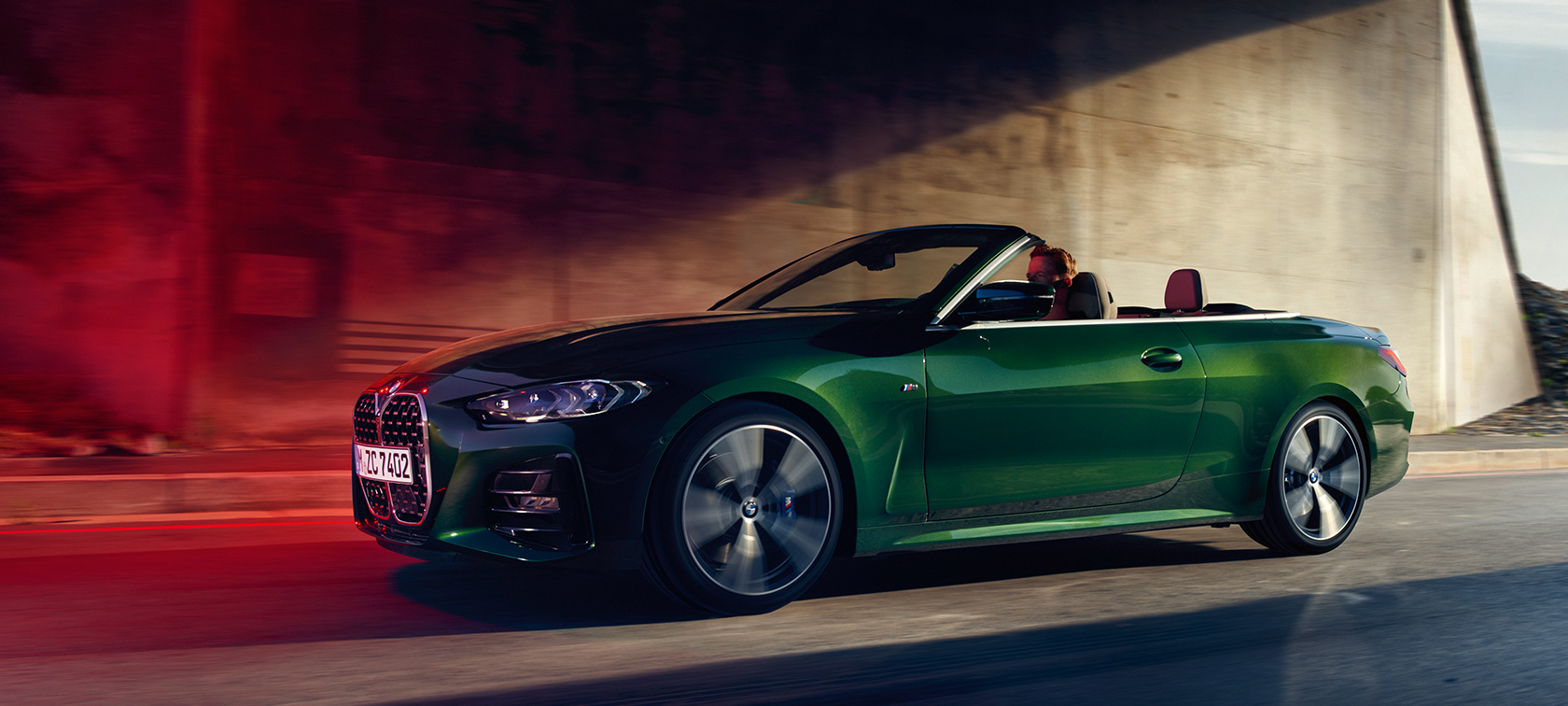 Važiuojančio BMW 4 serijos kabrioleto G23 2020 trijų ketvirčių vaizdas iš šono BMW 4 serijos kabrioleto G23 2020 žalios „Sanremo Green“ metaliko spalvos važiuojančio automobilio trijų ketvirčių vaizdas iš šono