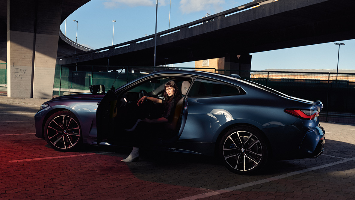 Lengvojo lydinio ratlankių vaizdas iš šono, BMW 4 serija kupė (G22) 2020 BMW 4 serijos kupė (G22) 2020 mėlynos metalizuotos Arctic Race Blue spalvos vaizdas iš šono, lengvojo lydinio ratlankiai su atviromis durelėmis ir modeliu automobilyje