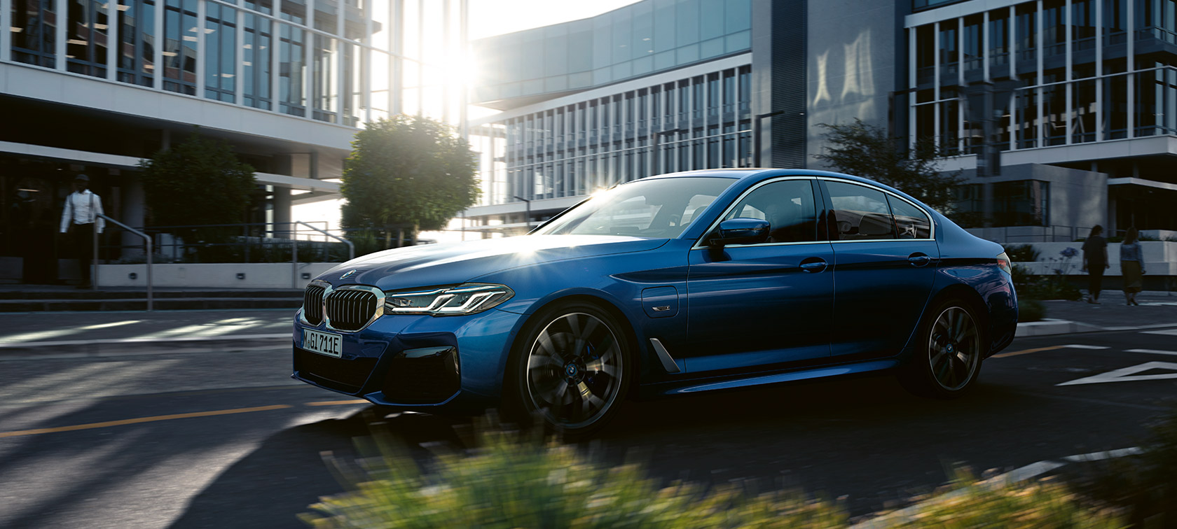 BMW 5 serijos sedanas (G30) Facelift 2020 mėlynos metalizuotos Phytonic Blue spalvos, važiuojančio automobilio trijų ketvirčių vaizdas iš priekio