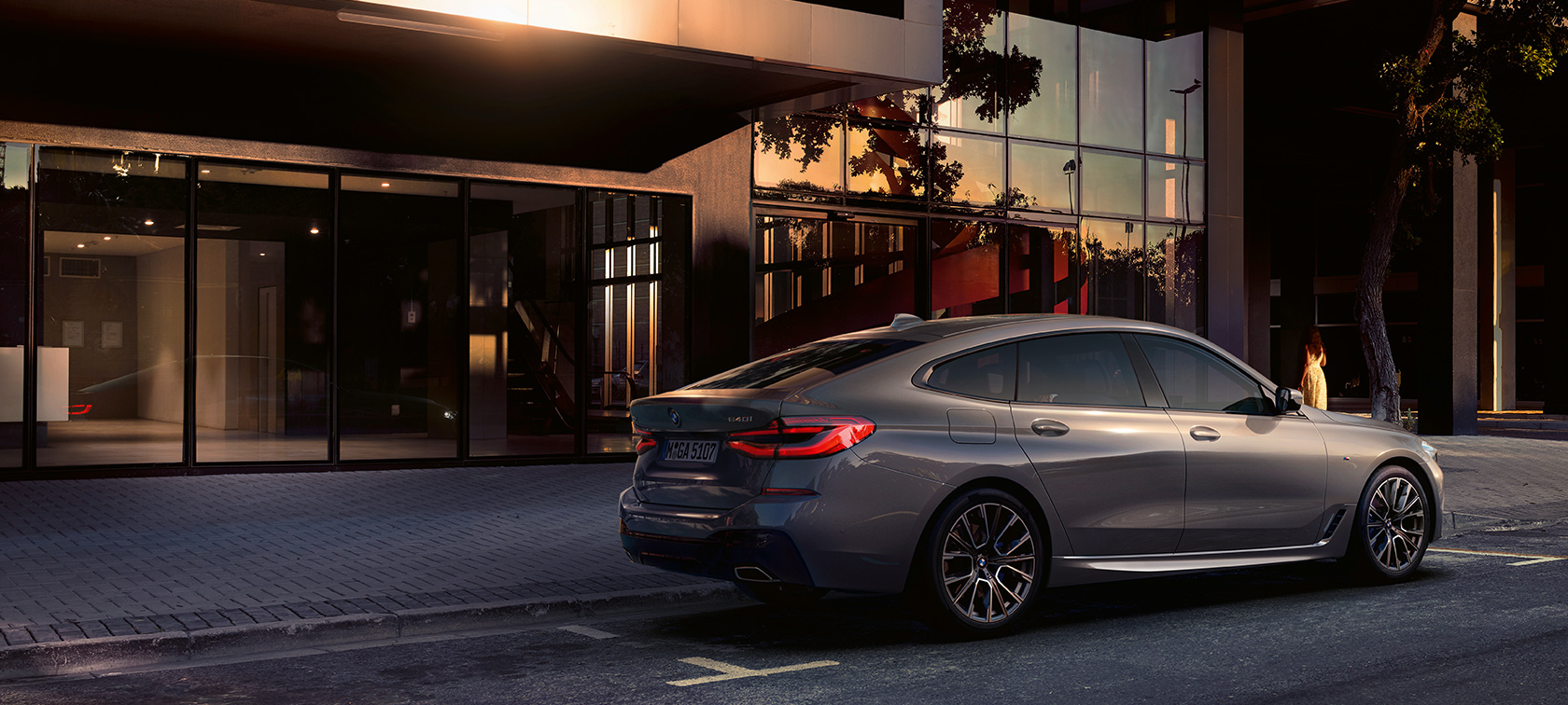 BMW 6 serijos Gran Turismo G32 2020 BMW 6 serijos Gran Turismo 640i xDrive G32 2020 pilkos Bernina Grey spalvos, prie pastato pastatyto automobilio galinis vaizdas iš šono