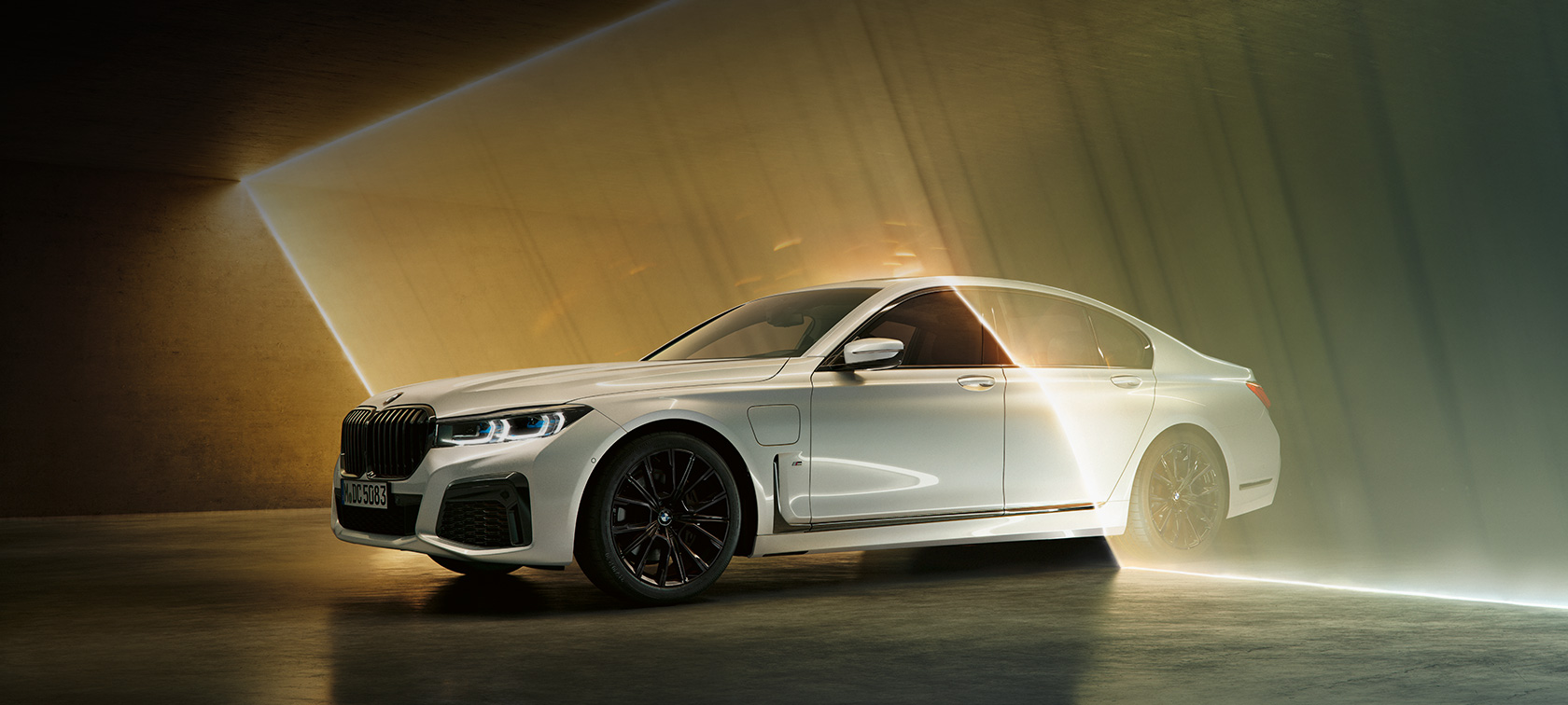 Balto BMW 7 serijos sedano trijų ketvirčių vaizdas iš priekio. BMW 7 serijos sedanas: apsupto šviesos spindulių balto BMW trijų ketvirčių vaizdas iš priekio