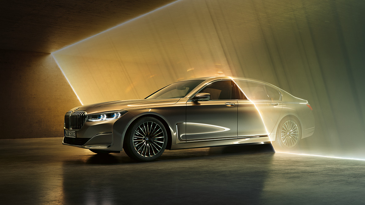 BMW 7 serijos sedano (G11 G12) 2019 apšviestas automobiio galas BMW 7 serijos sedanas (G11 G12) 2019 pilkos Bernina Grey spalvos su tviskančio gintaro efektu, priartintas apšviesto automobilio vaizdas iš galo