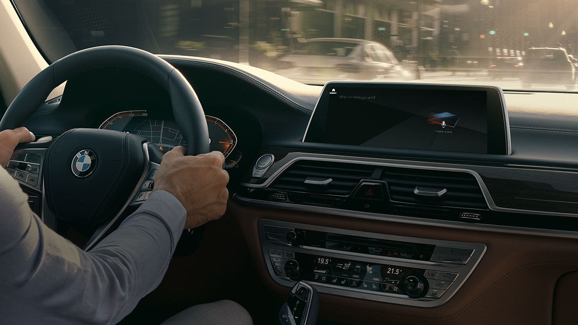 BMW 7 serijos sedano (G11 G12) 2019 BMW išmanusis asmeninis asistentas BMW 7 serijos sedano (G11 G12) 2019 salone sėdintis vyras, ekrano vaizdas su BMW išmaniuoju asmeniniu asistentu