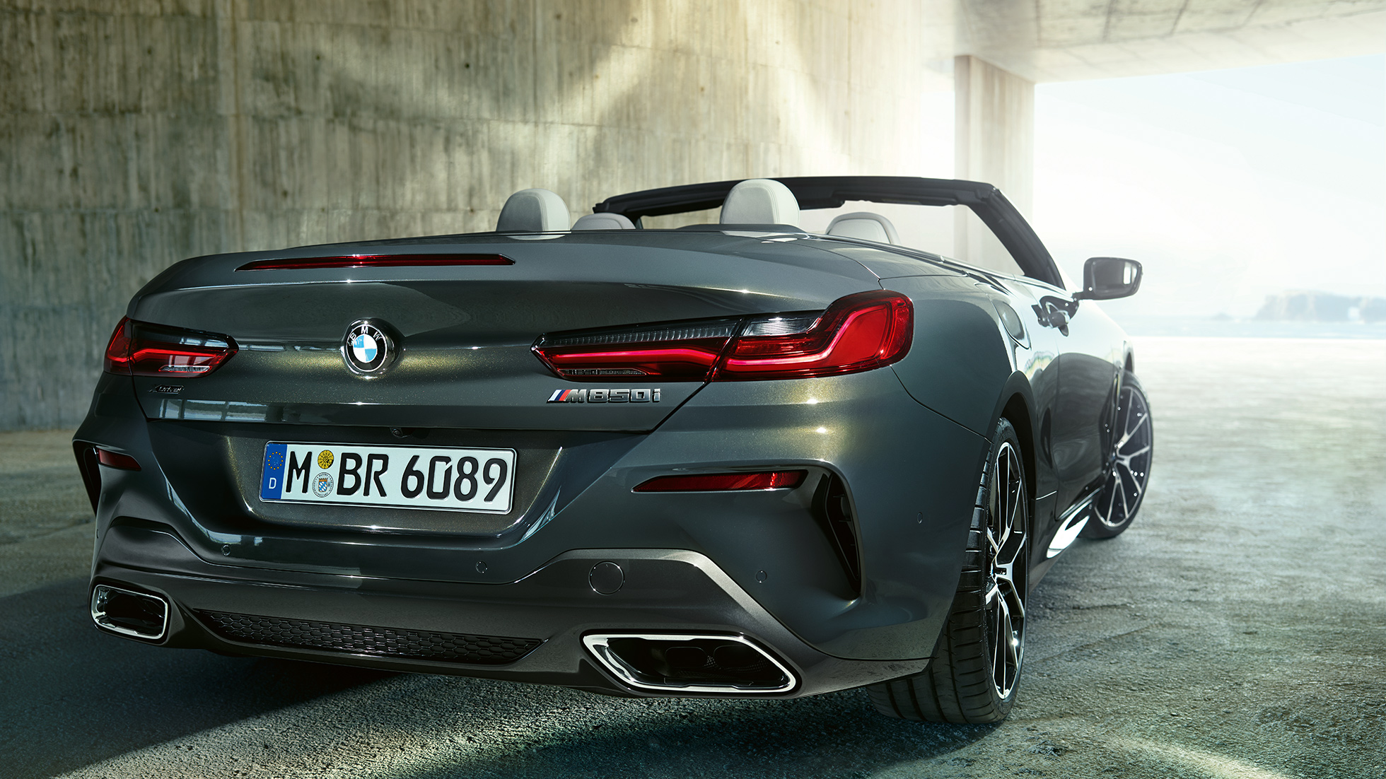 BMW M850i xDrive „Dravit Grey“ pilko metaliko spalvos, trijų ketvirčių vaizdas iš automobilio galo dešinės. BMW M850i xDrive „Dravit Grey“ pilko metaliko spalvos, trijų ketvirčių vaizdas iš automobilio galo dešinės.