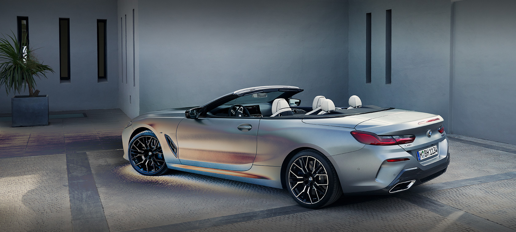 Vaizdas iš šono BMW 8 serijos kabrioletas G14 LCI Facelift 2022 stovintis pastato fone