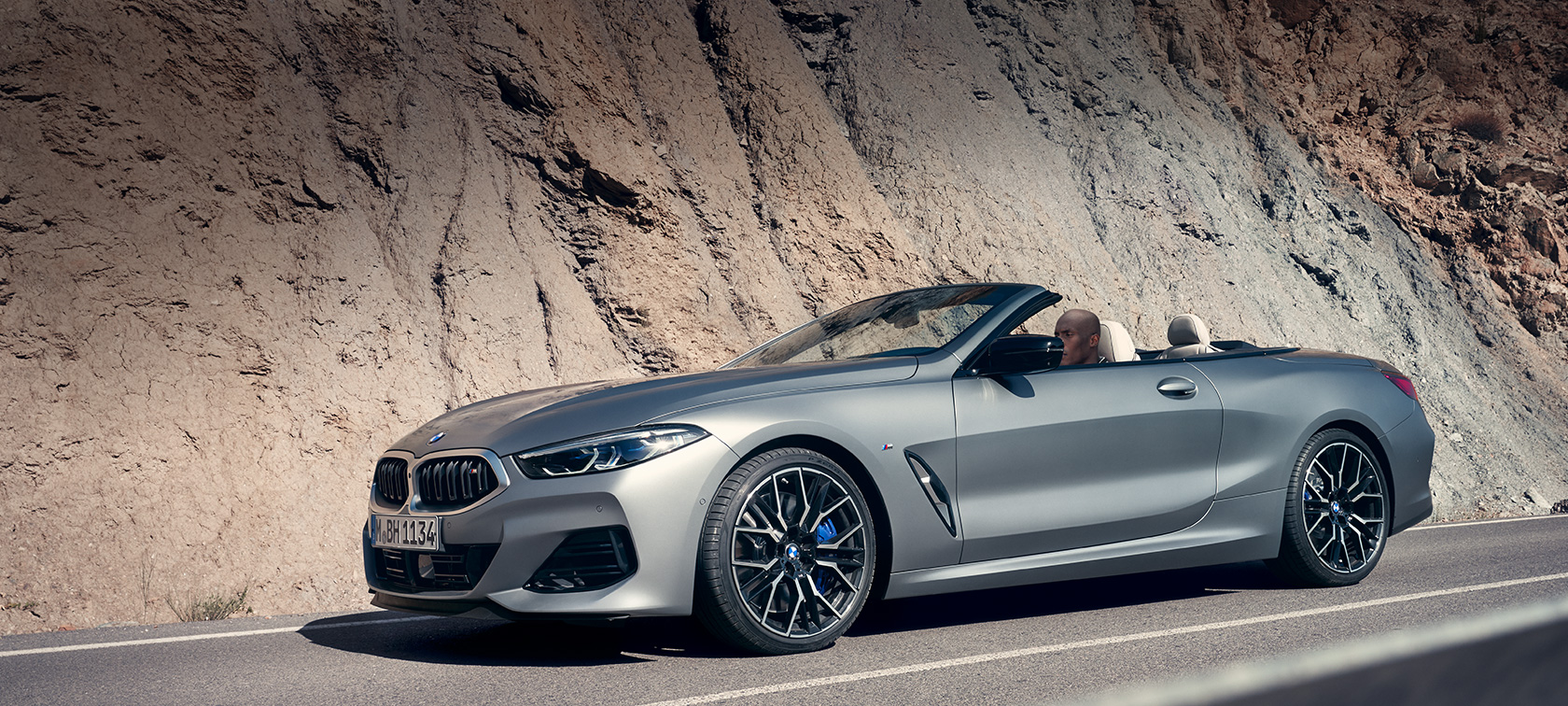BMW 8 serijos kabrioletas G14 LCI Facelift 2022 BMW M850i xDrive BMW Individual pilkos metalizuotos Frozen Pure Grey spalvos trijų ketvirčių vaizdas iš šono pastato fone BMW 8 serijos kabrioletas G14 LCI Facelift 2022 BMW M850i xDrive BMW Individual pilkos metalizuotos Frozen Pure Grey spalvos trijų ketvirčių vaizdas iš šono pastato fone