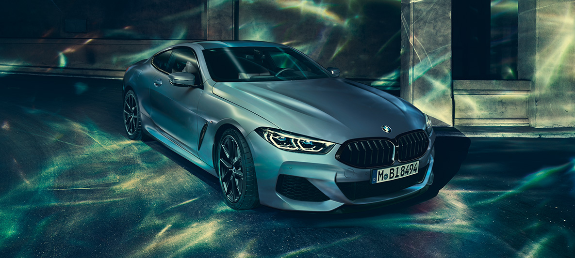 BMW M850i Coupé First Edition, trijų ketvirčių vaizdas iš priekio Miesto fone stovinčio BMW M850i Coupé First Edition trijų ketvirčių vaizdas iš priekio