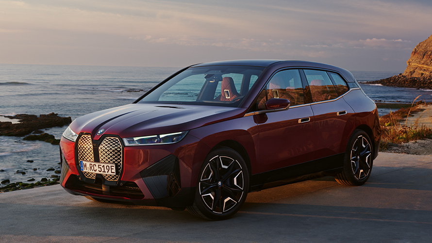 BMW iX (i20) elektrinis SUV BMW iX xDrive50, aerodinamiška išvaizda BMW iX (i20) 2021 elektrinis SUV BMW (i20) xDrive50 raudonos Aventurin Red spalvos, šoninis eksterjero vaizdas