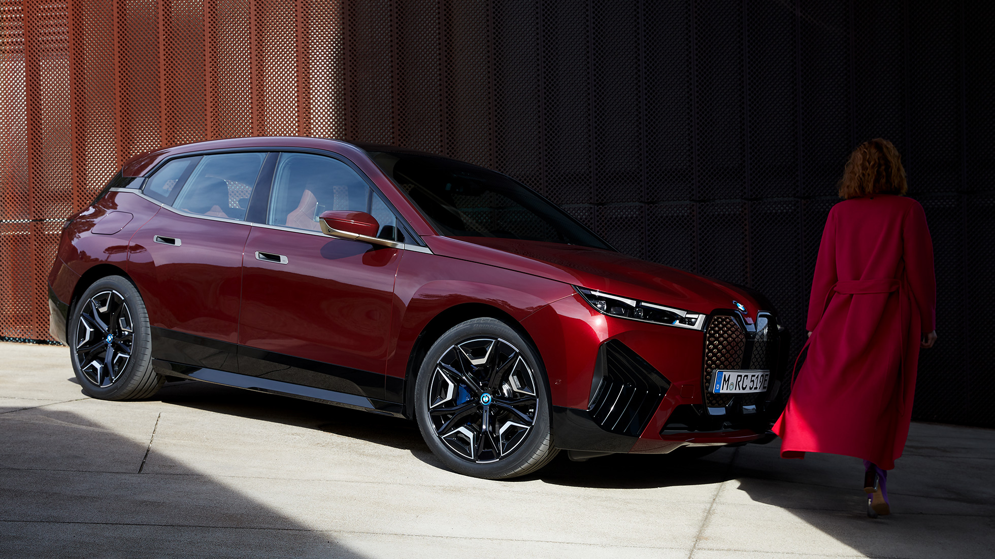 BMW iX trijų ketvirčių vaizdas iš šono, eksterjeras BMW iX raudonos Aventurin Red spalvos, i20 trijų ketvirčių vaizdas iš šono,eksterjeras