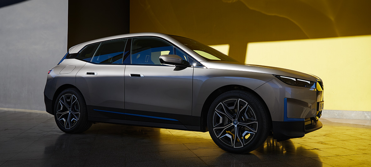 BMW iX stovinčio automobilio trijų ketvirčių vaizdas iš šono BMW iX sidabro Cashmere Silver spalvos stovinčio i20 trijų ketvirčių vaizdas iš šono