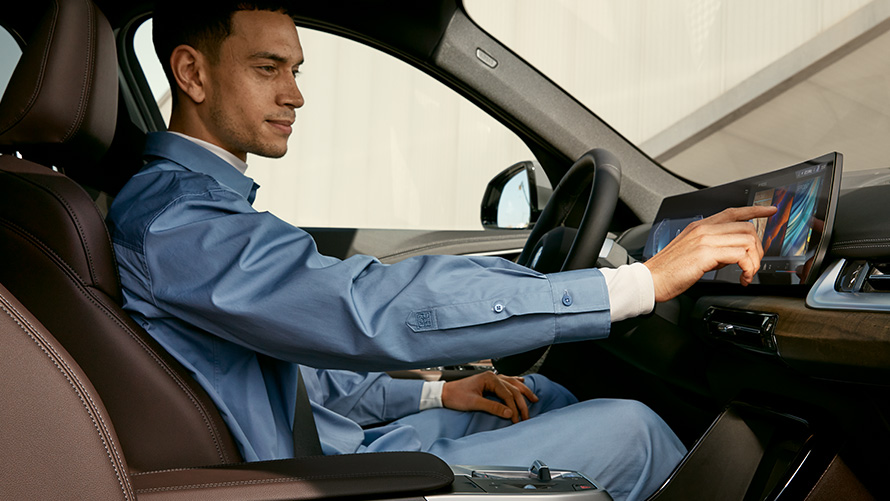 BMW iX1 U11 BEV interjeras jutiklinis valdymas BMW iX1 U11 BEV interjeras vairuotojo jutiklinis valdymas išlenktame ekrane
