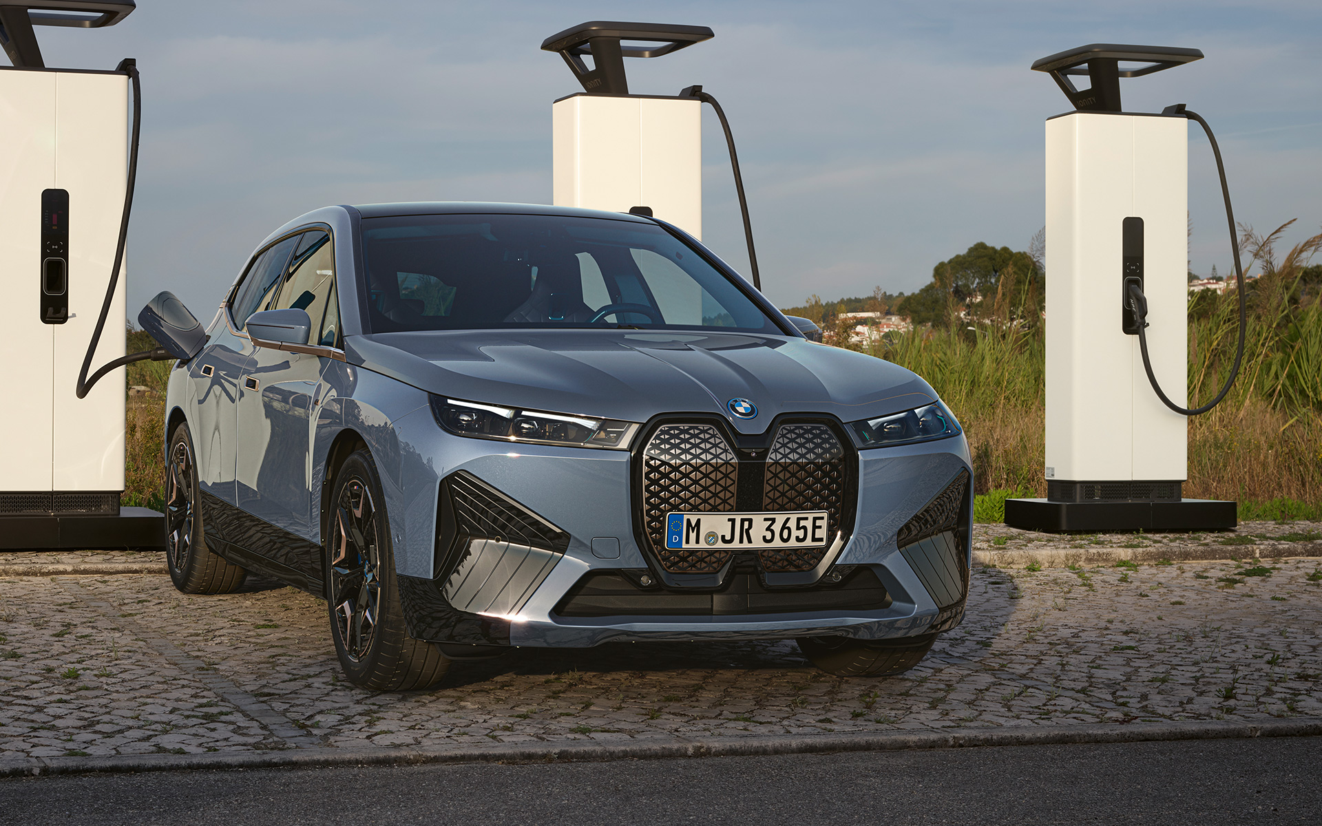 BMW iX M60 i20 2022 elektrinis SUV elektromobilis pilkos BMW Individual Storm Bay metalizuotos kėbulo spalvos automobilio vaizdas iš priekio