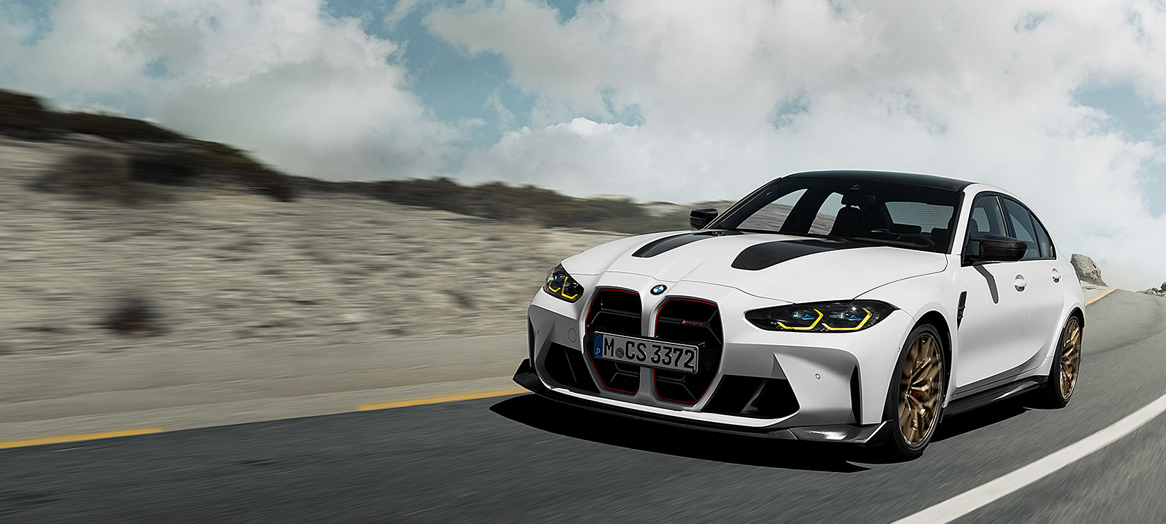 BMW M3 CS G80 lenktynių trasoje važiuojančio automobilio trijų ketvirčių vaizdas iš priekio