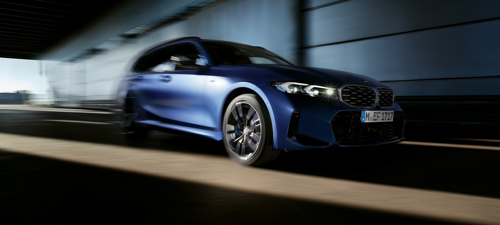Važiuojančio BMW M340i xDrive Touring G21 trijų ketvirčių vaizdas iš šono Važiuojančio BMW M340i xDrive Touring G21 trijų ketvirčių vaizdas iš šono