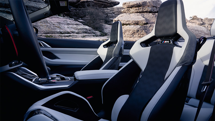Išlenktos M Carbon sėdynės, BMW M4 Competition kabrioletas su M xDrive (G83) 2021, interjero vaizdas su atviru minkštu stogu BMW M4 Competition kabrioletas su M xDrive (G83) 2021, išlenktos M Carbon sėdynės, interjero vaizdas su atviru minkštu stogu